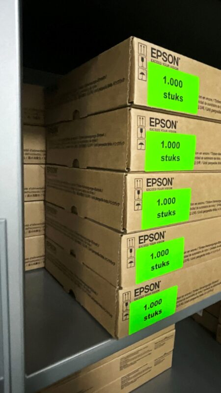 Fluor etiketten voor magazijnbeheer en inventarisatie Fluor etiketten met '1.000 stuks' op dozen in een magazijnstelling voor eenvoudig voorraadbeheer.